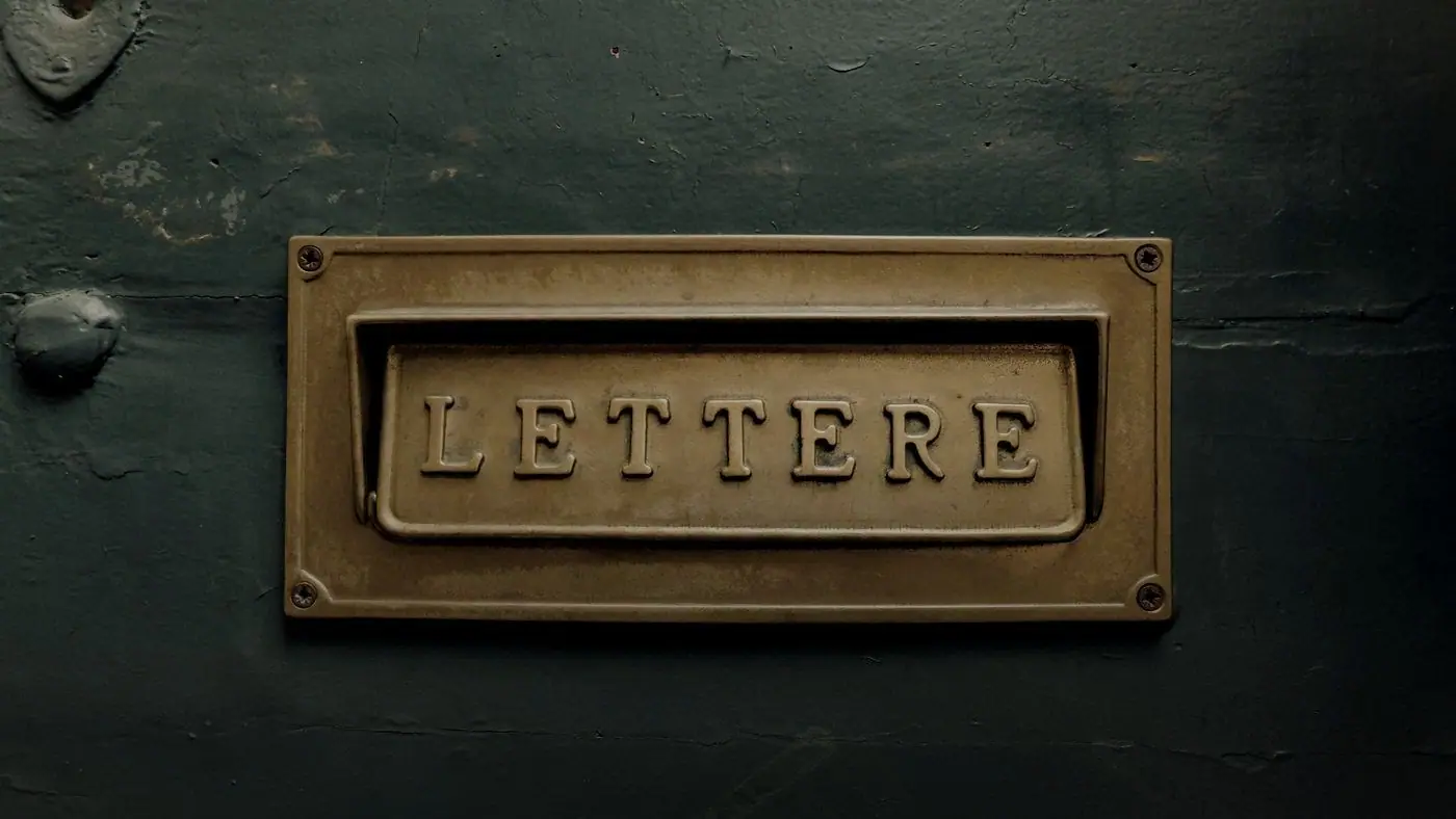 A brass letterbox plate engraved Lettere on a painted door